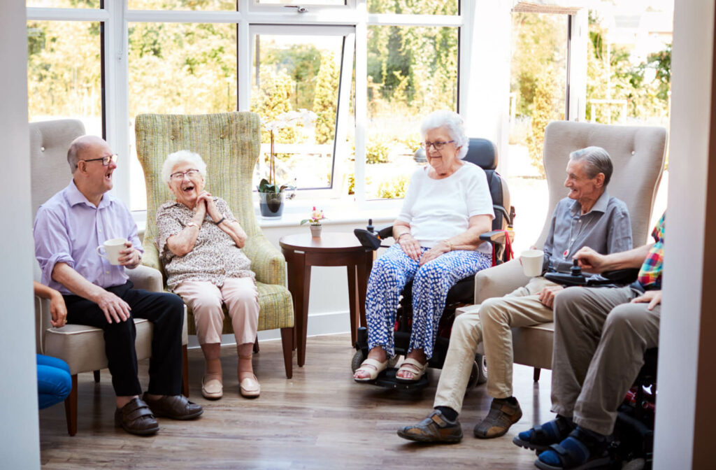a group of seniors socialize in an assisted living community